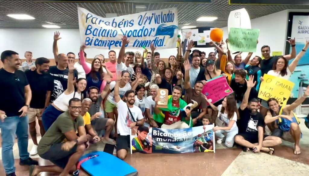 IMG Com cartazes e muita emoção, Uri Valadão foi recepcionado no aeroporto de Salvador após conquistar seu segundo título mundial de bodyboard. AOS Mídia registrou tudo.